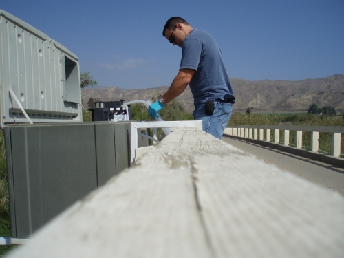 Tommy Liddell calibrating the peristaltic pump at the Upper Santa Clara River Monitoring Site (Apr. 2004)